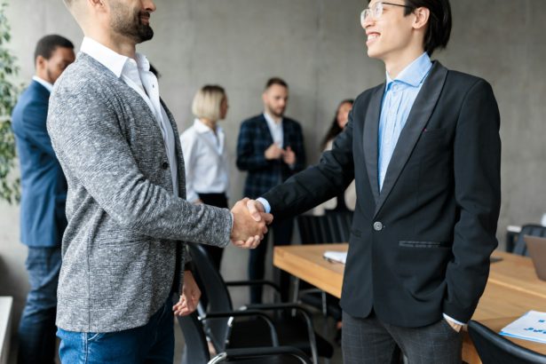 Two Businessmen Shaking Hands After Successful Negotiations In Office